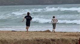 Joe and Josh feel the pull of the open sea at Harlyn Bay Beach despite the windy weather, 34.5 miles into the ride